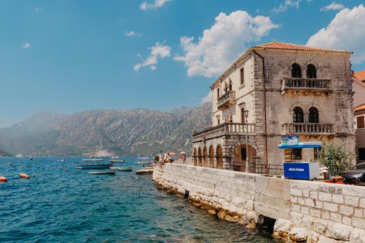 Historic city of Perast at Bay of Kotor in summer, Montenegro. Scenic panorama view of the historic town of Perast at famous Bay of Kotor with blooming flowers on a beautiful sunny day with blue sky and clouds in summer, Montenegro, southern Europe