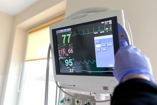 Nurse working with an hospital monitor marking vital signs