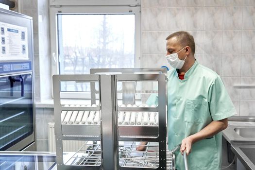 Male nurse sterilising supplies in an hospital