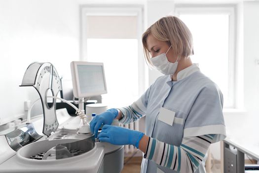 Female nurse using a centrifuge in a hospital