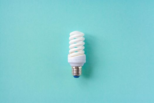 Energy saving light bulb on a blue background. Economical consumption of electricity. The concept of nature conservation
