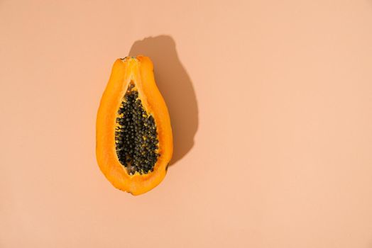single papaya fruit cutter on half on pastel background. copy space