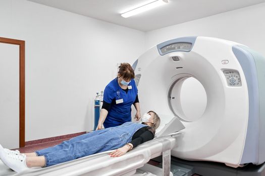 Patient lying in a ct scan machine net to a doctor in a hospital