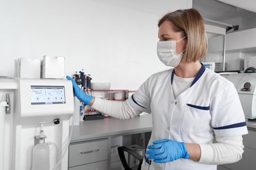 Doctor with uniform and facial mask using medical equipment in an hospital office