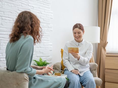 The psychologist uses metaphorical cards in a session with a patient. Caucasian woman tells associations