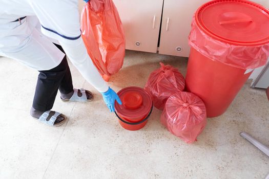 Top view of a laboratory technician throwing rubbish in containers for biochemical waste
