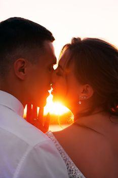 A kiss of the bride and groom at sunset. Wedding article. A happy couple. Love. Photos for printed products. Romance
