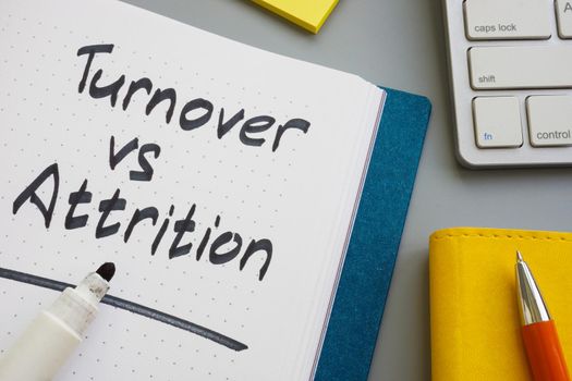 Turnover vs attrition words in a notepad and marker.