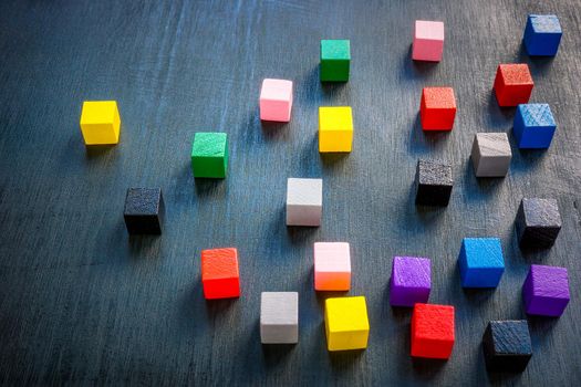 Colored cubes on dark surface. Leadership concept.