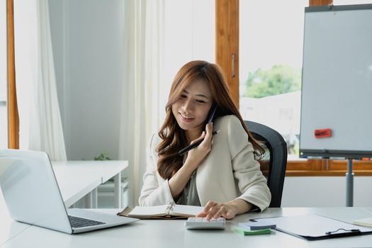 Busy business accountant woman making call phone in office and business working background, tax, accounting, statistics and analytic research concept.