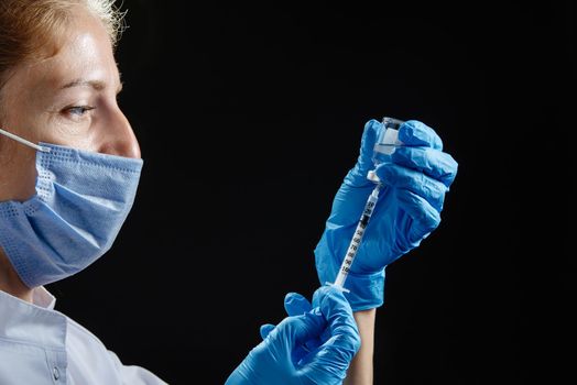 The doctor prepares to give the injection. A female nurse fills the syringe with medicine