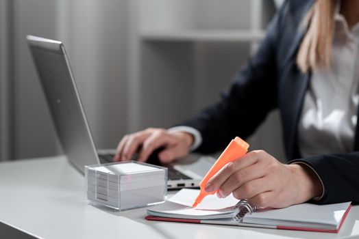 Businesswoman Writing In Notebook And Typing On Lap Top Od Desk With Notes.