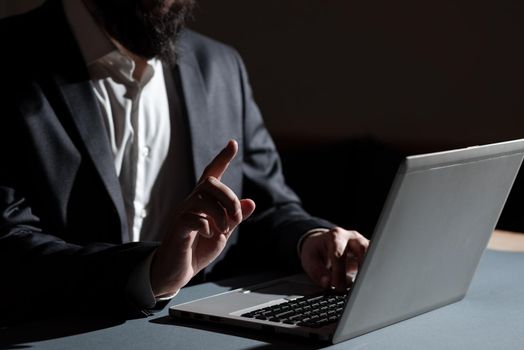 Man Typing Important Data Into Laptop And Pointing New Idea With One Finger