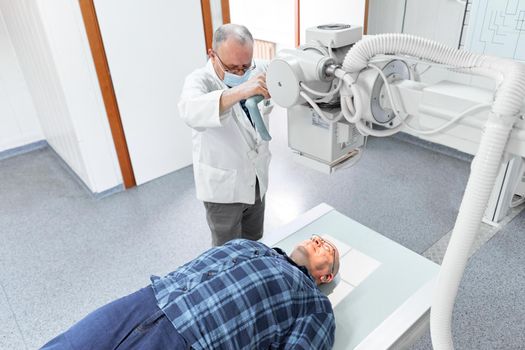 Top view of a x-ray room of a hospital with a patient and a doctor