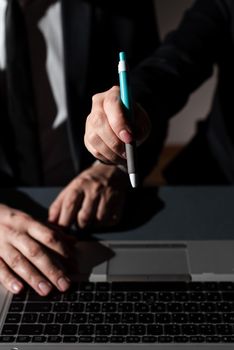 Man Typing On Lap Top And Woman Pointing With Pen On Important News.