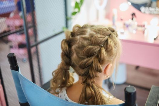 Hairdressing services. Reating hairstyle. Hair styling process. Children hairdressing salon.