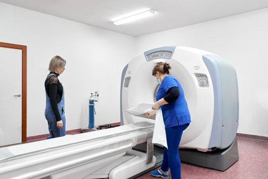 Patient and doctor next to a machine to take a tomography