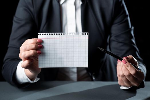 Businesswoman Holding Note With Important Message And Pointing With Pen.