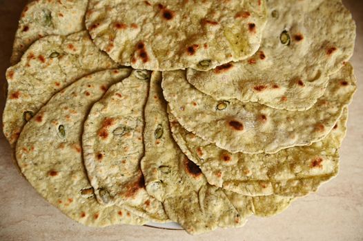 Close-up. Top view. Overhead view of round shaped pita bread stacked on a plate. Bakery. Homemade baked food. Food background. Flat lay. Still life