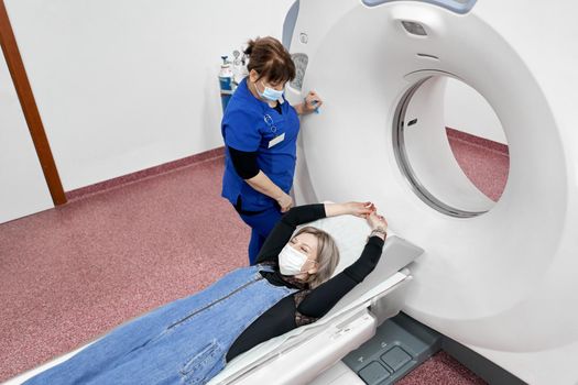 Top view of a patient lying on the stretcher of a ct scan machine in a hospital