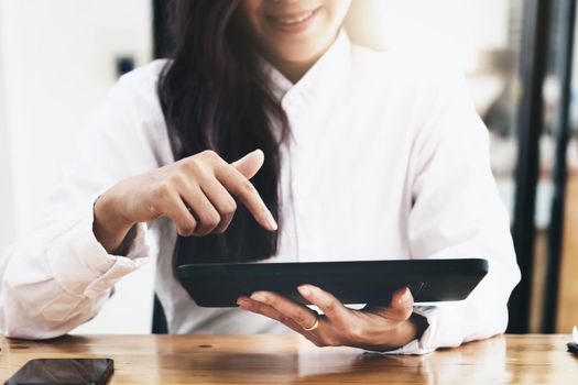 Woman using ipad for working in office room