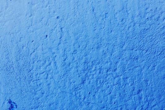 Texture from a wall with old blue paint damaged by time. Abstract background for design, place for text.