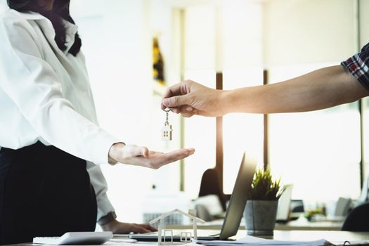 Real estate agents agree to buy a home and give keys to clients at their agency's offices. Concept agreement