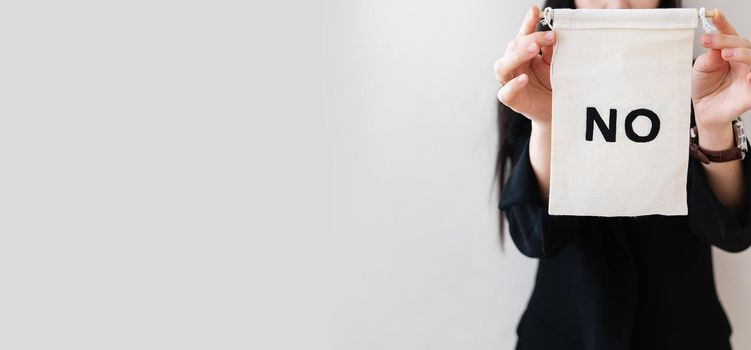 Young business woman in a black suit shows a blank white billboard on a white isolated background. There is no inscription on the poster. Concept for business and advertising. Banner