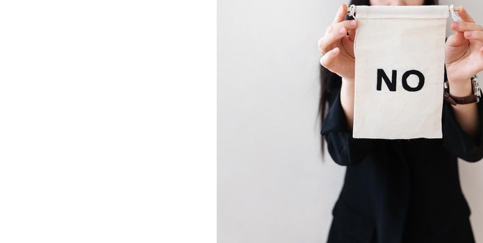 Young business woman in a black suit shows a blank white billboard on a white isolated background. There is no inscription on the poster. Concept for business and advertising. Lots of space for writing. Banner