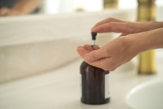 The girl washes her hands with liquid soap under water, the woman takes care of her health and cleanliness, disinfects her hands.