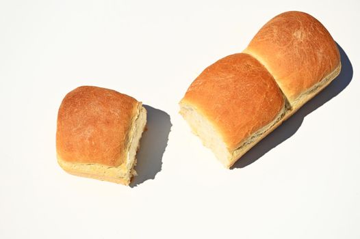 Overhead view of delicious loaves of freshly baked whole grain bread isolated on white background with copy space for advertising text. Still life. Food background