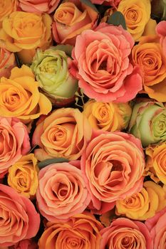 Yellow, orange and pink roses in a floral arrangement at a wedding