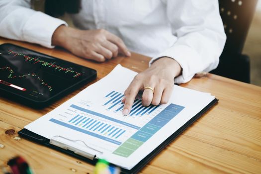 New normal, self-employed women pointing document stock and using a tablet to trade stocks for profit, buying and selling