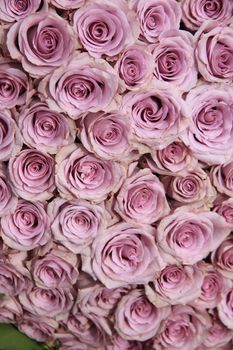 Purple roses in a big floral wedding arrangement