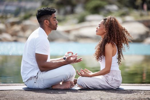 Yoga is at the center of their relationship. Full length shot of a young couple practicing yoga at the beach