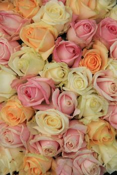 Pastel roses in various colors in a mixed wedding arrangement