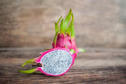 Healthy dragon fruits on old wooden background.