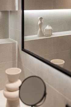 Modern bathroom interior with mirror and decorative elements in reflection. Minimalist style