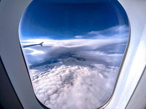 Clouds and sky as seen through window of an aircraft