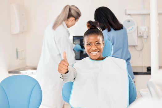 This is a great place to be. a young woman in her dentists office giving the thumbs up