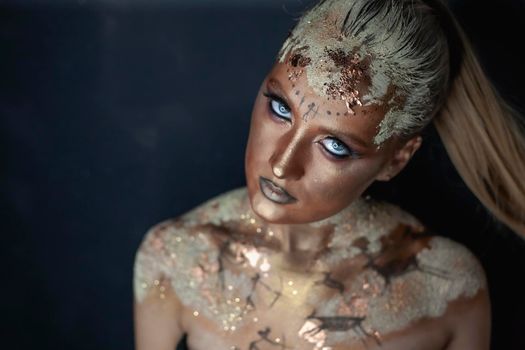 Portrait of female model with creative prehistoric makeup with cave painting