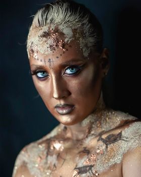 Portrait of female model with creative prehistoric makeup with cave painting