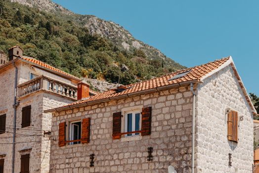 Historic city of Perast at Bay of Kotor in summer, Montenegro. Scenic panorama view of the historic town of Perast at famous Bay of Kotor with blooming flowers on a beautiful sunny day with blue sky and clouds in summer, Montenegro, southern Europe