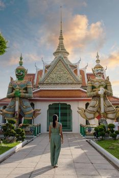 Wat Arun temple Bangkok Thailand, Temple of Dawn, Buddhist temple alongside Chao Phraya River.Beautiful Wat Arun at dusk evening sunset, Asian woman visiting temple