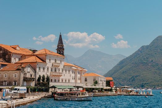 Historic city of Perast at Bay of Kotor in summer, Montenegro. Scenic panorama view of the historic town of Perast at famous Bay of Kotor with blooming flowers on a beautiful sunny day with blue sky and clouds in summer, Montenegro, southern Europe