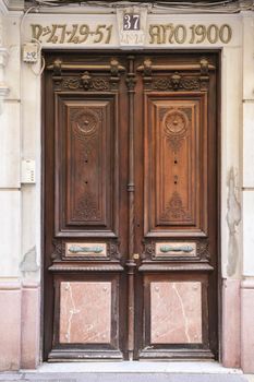 Cartagena, Murcia, Spain- July 18, 2022: Old wooden and marble door with beautiful iron door handle