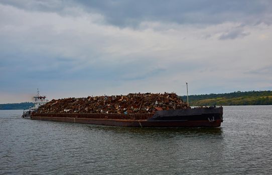 Transportation industry. Ship barge transports scrap metal and sand with gravel.