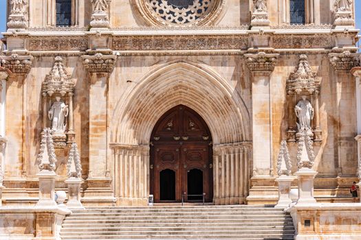 The entrance portal with the stairs on the baroque facade of the monastery church of Alcobaca, Portugal