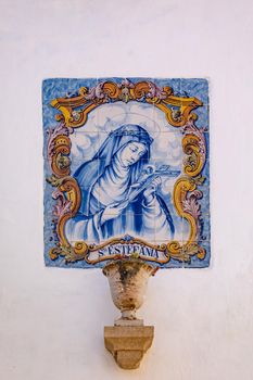 Mural of the holy Sta Estefania made of 42 painted ceramic tiles called azulejos on a house wall, Obidos, Portugal