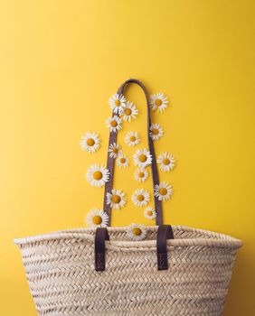 daisies fall into a straw bag. summer concept